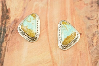 Genuine Number 8 Mine Turquoise Stones set in Sterling Silver Post Earrings. The Number 8 mine is located in Eureka County Nevada. Since 1976 there has been no Number 8 Turquoise mined. There is however, an existing stock pile that Mr. Dowell Ward, the last owner of the Number 8 mine, had stocked away for later sorting. The Turquoise is a collector's item--because once the reserve is gone there will be no more material released onto the market. The Gold Mining Company owns the claim to the Number 8 mine and it has been swallowed up by the gold mining operations. This is some of the last Number 8 Turquoise to be had and will be a great addition to your collection. Created by Navajo Artist Arkie Nelson. Signed by the artist.